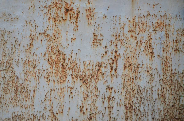 Rusty metal texture with scratched surface. Old painted metal wall with peeling paint. Texture obsolete painting metal fence close-up