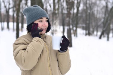 Smartphone ve kahve Kupası ile genç kız kış portresi