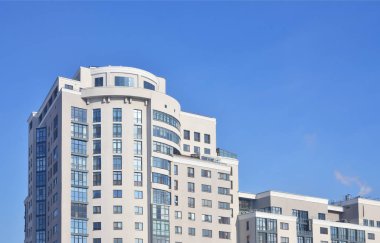 Çok katlı ofis ile lots-in cam pencere bej renk saf mavi gökyüzü bir arka plan üzerinde. Yeni inşa edilen ofis alanı Kiralık