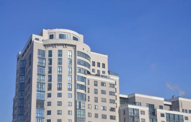 Çok katlı ofis ile lots-in cam pencere bej renk saf mavi gökyüzü bir arka plan üzerinde. Yeni inşa edilen ofis alanı Kiralık