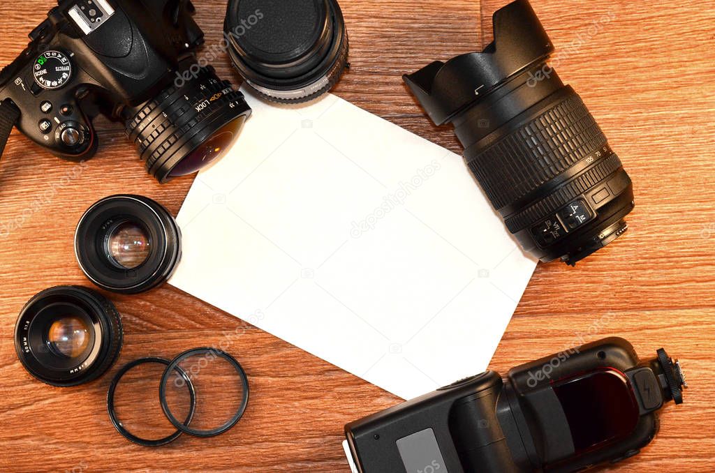 Complete kit for modern digital SLR camera and blank sheet of paper for copyspace. Cover for online photo accessories and devices shop or main slide for photography presentation