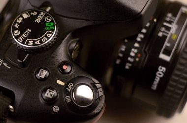 Modern bir dijital Slr fotoğraf makinesinin yakın çekim makro çekim. Siyah kamera gövdesi klasik geniş diyafram portre objektifi ile detaylı fotoğraf
