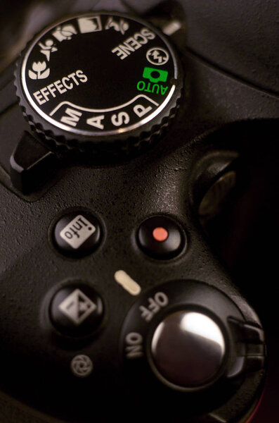 Крупный план современной цифровой SLR камеры. Подробное фото тела черной камеры с кнопками для управления и переключения режимов съемки
