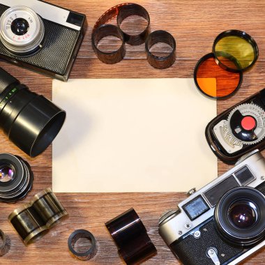 Retro kamera ve ahşap masa üzerinde eski fotoğraflar. Vintage film kamera ve lens ile resim veya logo tasarım sunum için sahte. Yukarıdan görüntülemek