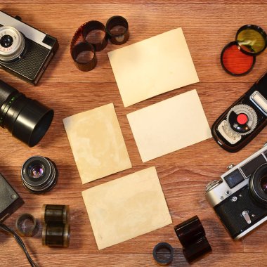 Vintage retro kamera ve resim veya metin yer için boşlukları fotoğraflarla bir arka plan olarak ahşap yüzeyde eski fotoğraf aksesuarları