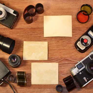 Vintage retro kamera ve resim veya metin yer için boşlukları fotoğraflarla bir arka plan olarak ahşap yüzeyde eski fotoğraf aksesuarları