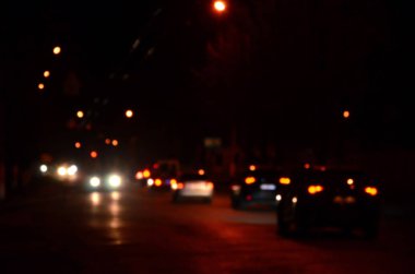 Gece ışıkları büyük şehir, bokeh trafik ışıkları ve yaklaşan araba farlar ile bulanık gece avenue