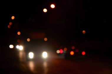 Gece ışıkları büyük şehir, bokeh trafik ışıkları ve yaklaşan araba farlar ile bulanık gece avenue
