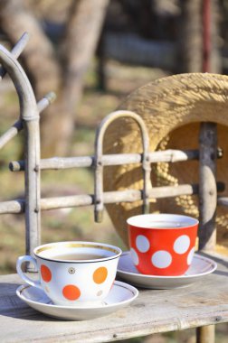 Bir bardak çay ve hasır şapka ile rustik natürmort