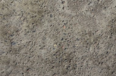 Doku kirli ve karanlık gri asfalt gündüz sırasında güneş ışığı altında. Kaba Asfalt yüzey yakın çekim. Eski beton yüzeyi, toprak ve kum ile kaplı