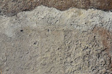 Doku kirli ve karanlık gri asfalt gündüz sırasında güneş ışığı altında. Kaba Asfalt yüzey yakın çekim. Eski beton yüzeyi, toprak ve kum ile kaplı