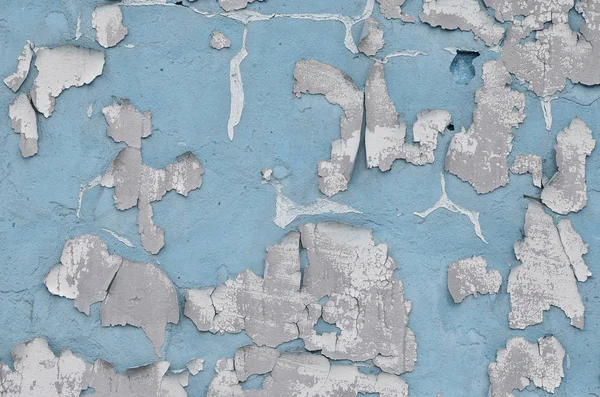 Close-up weathered and stained blue obsolete concrete wall texture. Old detailed surface with cracked paint layer