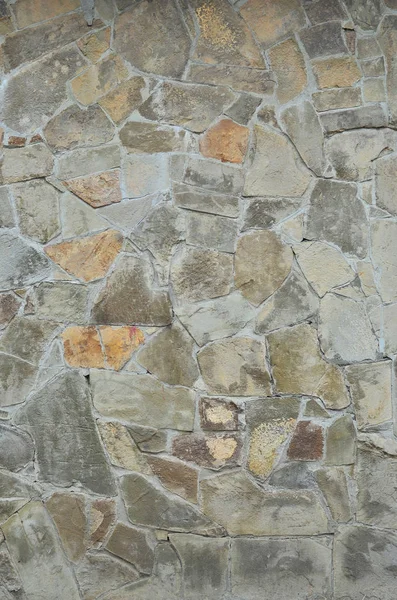 Stone wall background - building feature. Texture of thick and strong wall of rough stones of various shapes and sizes