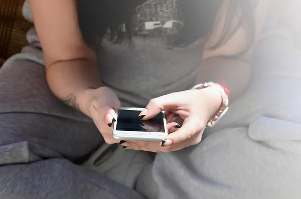 黑发的女孩使用现代触摸智能手机 — 图库照片