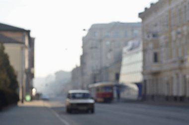 Arabalar ve tramvay Sisli sabah sırasında hareketli şehir sokaklarını bulanık manzara. Sanatsal bir bokeh etkisi ile bulanık manzara fotoğraf alımı