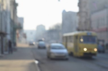 Arabalar ve tramvay Sisli sabah sırasında hareketli şehir sokaklarını bulanık manzara. Sanatsal bir bokeh etkisi ile bulanık manzara fotoğraf alımı