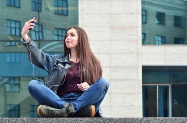 Genç kız selfie bir ofis binasının arka plan üzerinde yapıyor