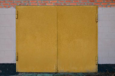 Tuğla garaj bir boyalı metal kapı doku. Eski tuğla duvar inşa büyük metal kapılar