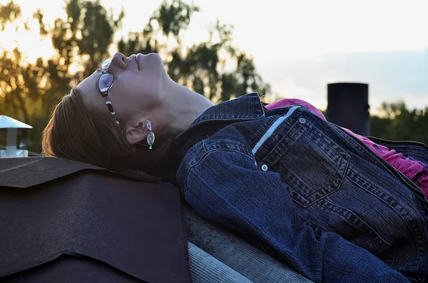 Gözlük ve kot ceketi giyen Kız çatıda dinleniyor — Stok fotoğraf