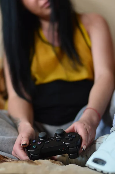 A young girl plays video games with a black joystick — Stock Photo, Image