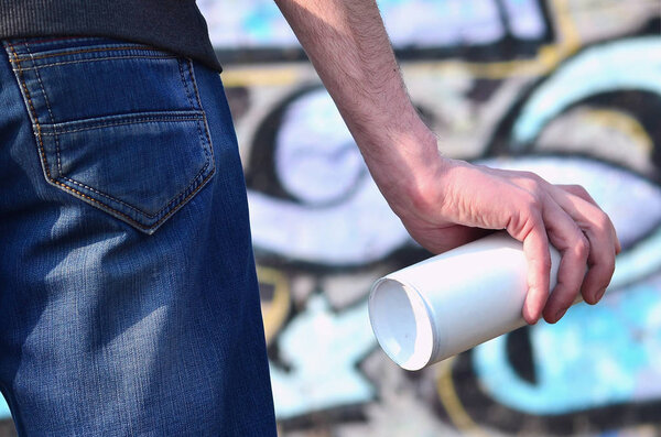 Фотография уличного художника, который рисует новую цветную картину на кирпичной стене. Одним из видов стрит-арта является молодежная граффити-культура. Оформление стен старых и заброшенных зданий
