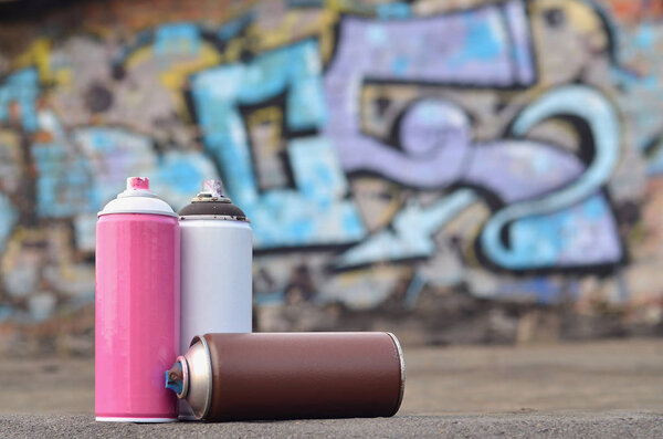 A still-life of several used paint cans of different colors