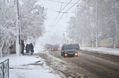 Kharkov, Ukrayna - 19 Nisan 2017: Beklenmeyen hızlı kar yağışı Nisan Kharkiv sokaklarda. Nisan ortasında karla kaplı yolda araba trafik