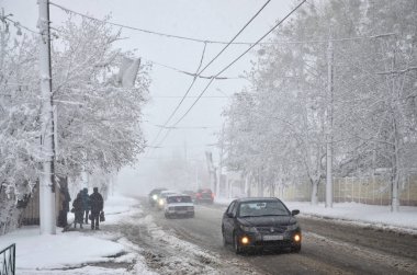 Kharkov, Ukrayna - 19 Nisan 2017: Beklenmeyen hızlı kar yağışı Nisan Kharkiv sokaklarda. Nisan ortasında karla kaplı yolda araba trafik