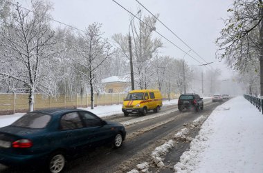 Kharkov, Ukrayna - 19 Nisan 2017: Beklenmeyen hızlı kar yağışı Nisan Kharkiv sokaklarda. Nisan ortasında karla kaplı yolda araba trafik
