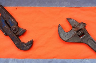 Ayarlanabilir ve boru anahtarı bir turuncu sinyal işçi gömlek arka planı. Natürmort onarım, tren veya sıhhi tesisat işleri ile ilgili