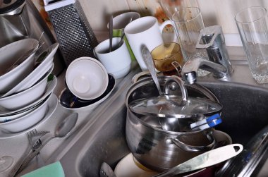 Yıkanmamış yemekleri mutfak lavabo ve tezgah üzerinde büyük bir yığın. Bir sürü aletleri ve mutfak aletleri yıkama önce. Günlük rutin ve karmaşıklık pişirme kavramı