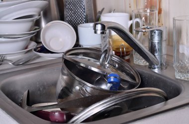Yıkanmamış yemekleri mutfak lavabo ve tezgah üzerinde büyük bir yığın. Bir sürü aletleri ve mutfak aletleri yıkama önce. Günlük rutin ve karmaşıklık pişirme kavramı