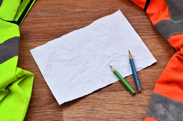 Crumpled Sheet Paper Two Pencils Surrounded Green Orange Working Uniforms — Stock Photo, Image