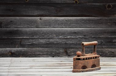 Ağır ve paslı eski kömür demir bir ahşap yüzeye yatıyor