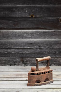 Ağır ve paslı eski kömür demir bir ahşap yüzeye yatıyor