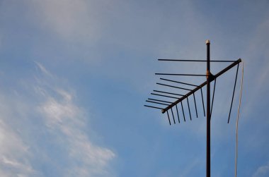 Eski ve paslı televizyon anten bulutlu mavi gökyüzü karşı. Özel evlerde televizyon sinyal almak için eski aygıt