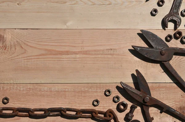 Un conjunto de herramientas viejas y oxidadas se encuentra en una mesa de madera en las obras —  Fotos de Stock