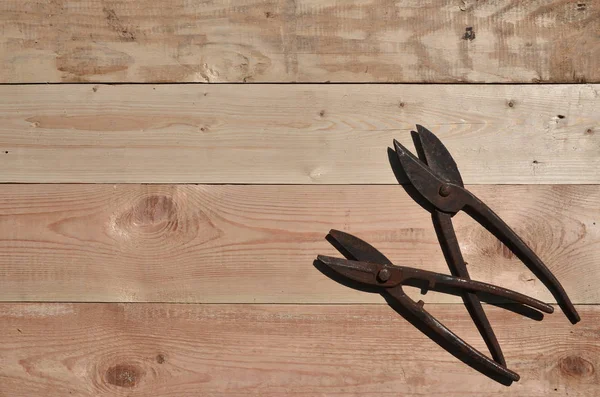 Unas tijeras oxidadas para metal se encuentran en una mesa de madera en una obra —  Fotos de Stock