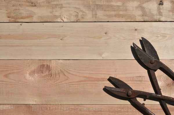 Unas tijeras oxidadas para metal se encuentran en una mesa de madera en una obra —  Fotos de Stock