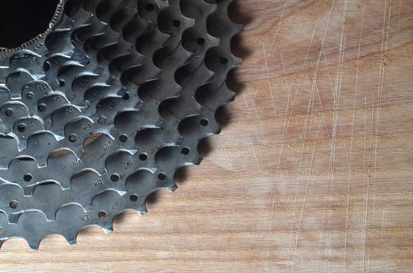 Cassete traseiro (roda dentada) de uma bicicleta de montanha deitada em uma madeira — Fotografia de Stock