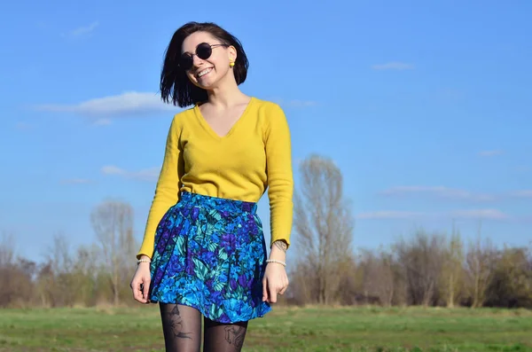 Attraktive und niedliche brünette Mädchen in einem gelben Pullover geht thro — Stockfoto