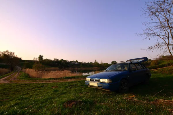Niebieski Samochód Tle Rustykalnym Krajobrazu Polem Dzikie Trzciny Małe Jezioro — Zdjęcie stockowe