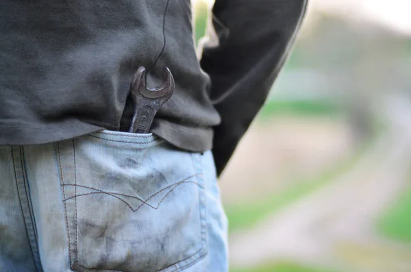 Roet in de jeans zak van een monteur buitenshuis — Stockfoto