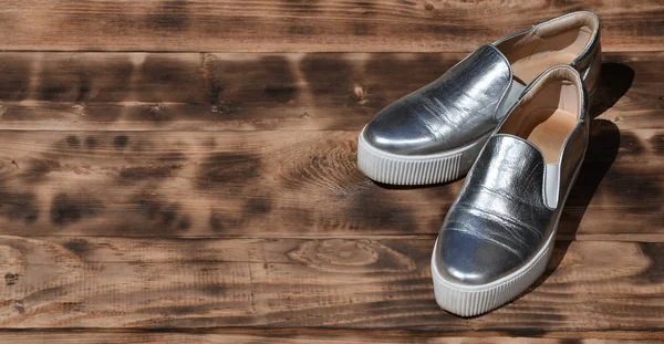 Original shiny shoes in disco style lie on a vintage wooden surface made from fried brown boards — Stock Photo, Image