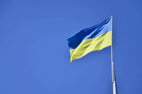 Український прапор на тлі безхмарне небо синє — стокове фото