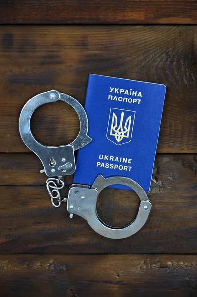 A rendőrség bilincs fekszik egy fából készült tabl ukrán útlevél — Stock Fotó