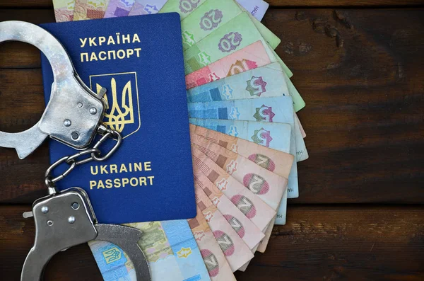Een foto van een Oekraïense buitenlands paspoort, een zekere mate van Oekraïense geld en politie handboeien — Stockfoto