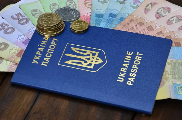Az ukrán útlevél és egy bizonyos pénzösszeg ukrán fafelületre fényképe — Stock Fotó