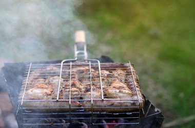 Şiş kebap üzerinden tavuk kanatları alanında yanmış. Klasik Barbekü açık havada. Kömür eti kızartma işlemi