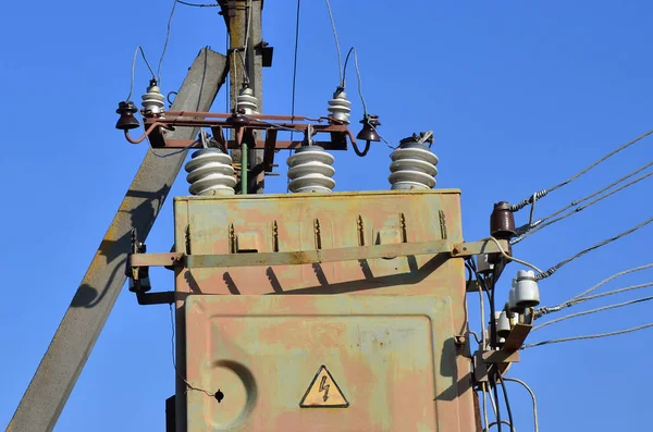 Antiguo y obsoleto transformador eléctrico sobre el fondo de un cielo azul sin nubes — Foto de Stock